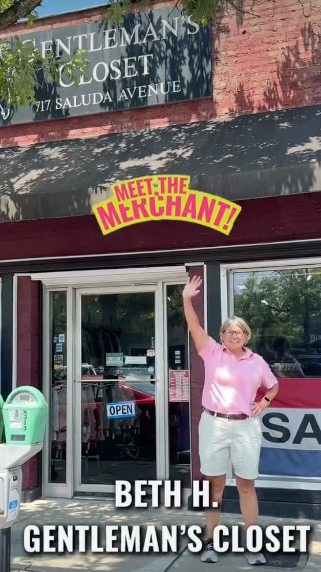 A frame from Gentlemen's Closet's Facebook Reel: the storefront sign, &ldquo;Meet the Merchant!&rdquo; over the awning, and Beth H. waving out front in a pink shirt, captioned &ldquo;Beth H., Gentleman's Closet.&rdquo;